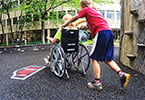 Friend pushing friend in wheelchair at park
