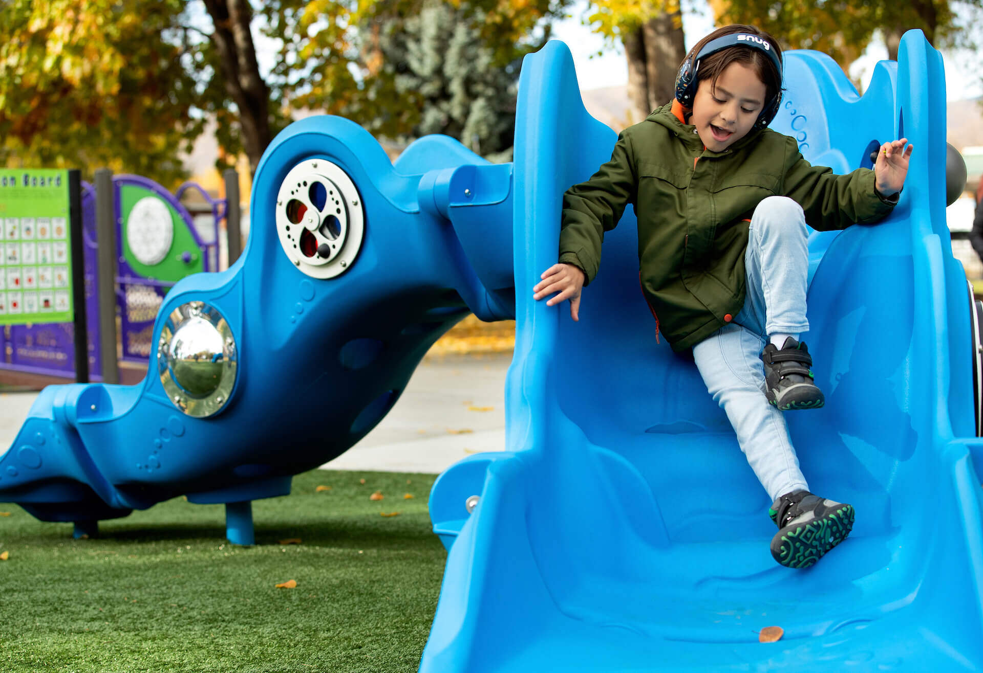 Child on blue playground slide
