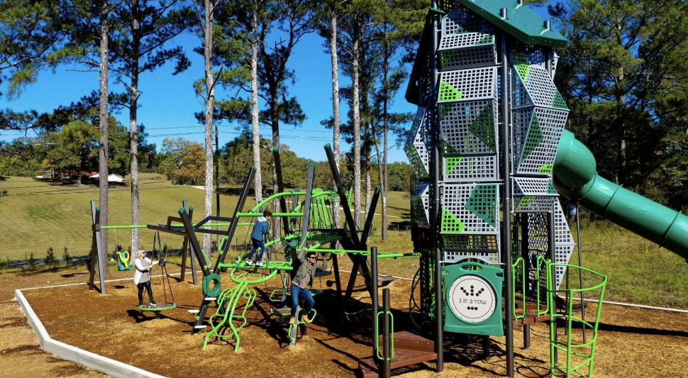 Bright green modern design play tower attached to commercial playground equipment