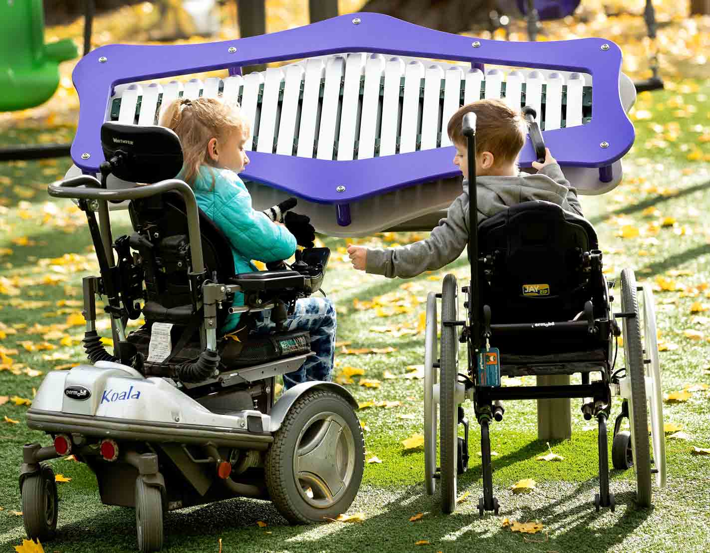 Children using mobility devices playing with outdoor music commercial playground equipment